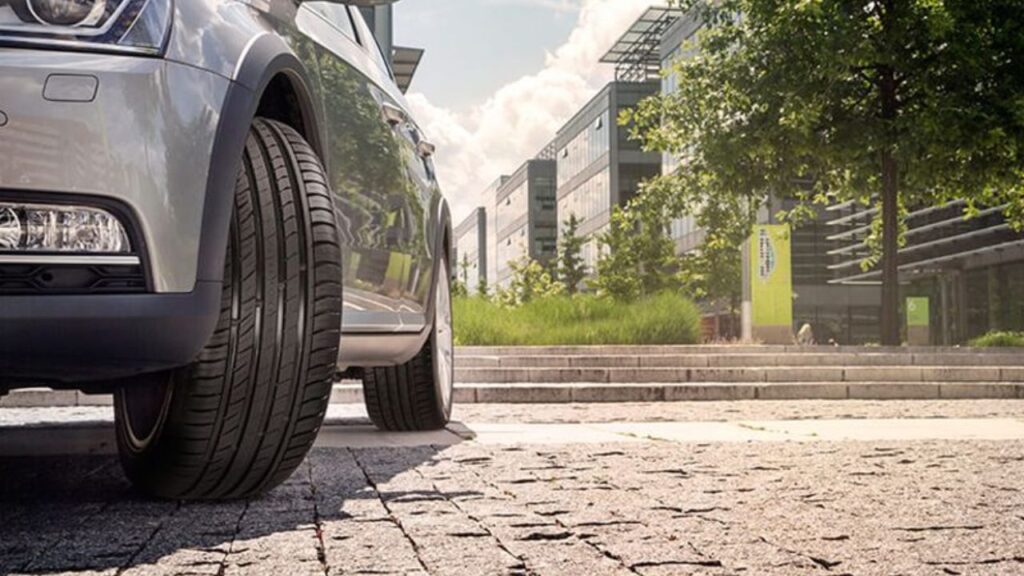 Samochód na miejskiej ulicy w słoneczny dzień na letnich oponach